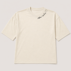 An off-white short-sleeve t-shirt with a small black script logo and heart outline on the upper right chest, displayed flat against a light gray background.