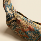Patterned crescent bag with a zipper on a beige background