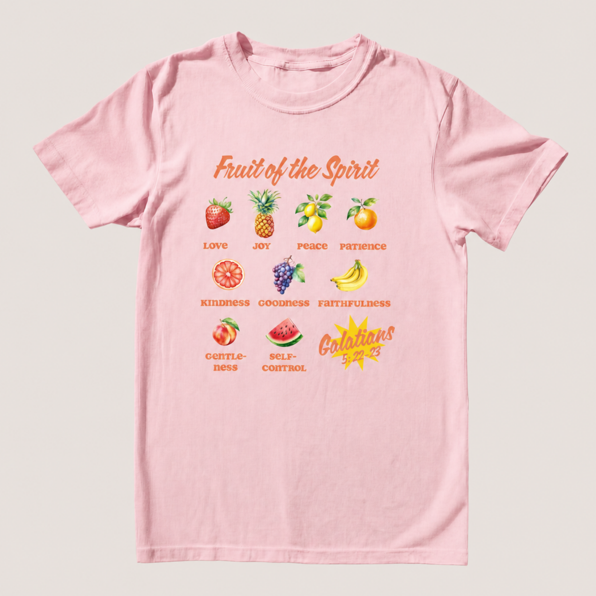 A light pink short-sleeve t-shirt with a 'Fruit of the Spirit' graphic print on the front, displayed flat against a light gray background.