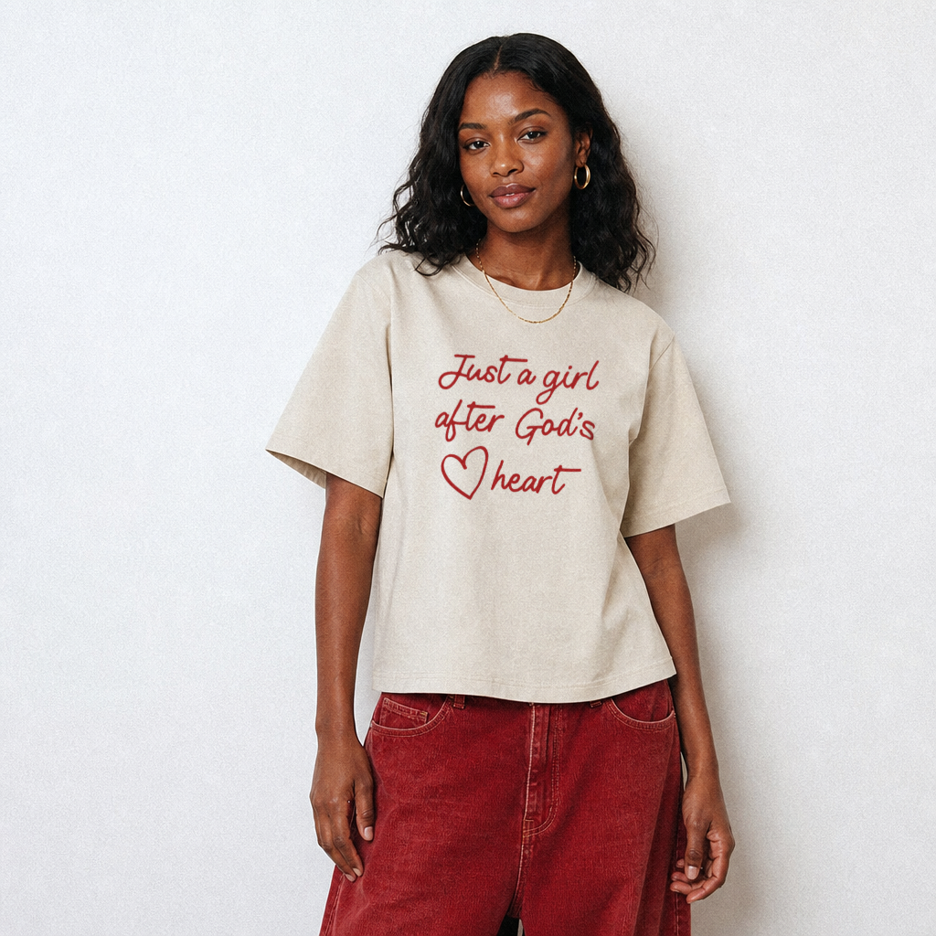 Woman wearing a beige t-shirt with red text and a heart symbol on a white background